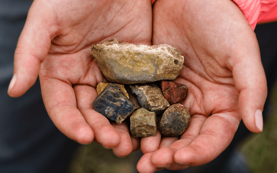 hands holding different size rocks